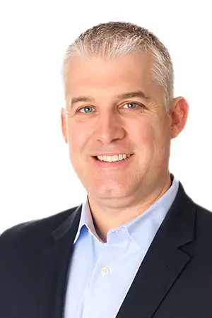 Dr. Rodgers Eckhart, board-certified ophthalmologist, smiling in professional attire, specializing in cataract surgery and refractive procedures at Advanced Eye Care Center.